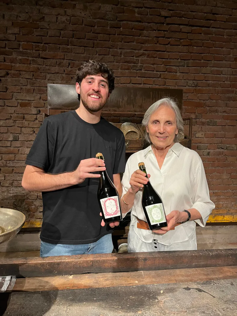 Two members of the Catena Institute of Wine team holding Domaine EdeM bottles at the winery