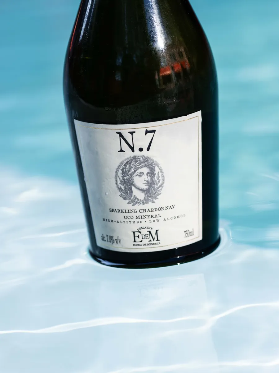 Bottle of UCO MINERAL at the edge of a pool